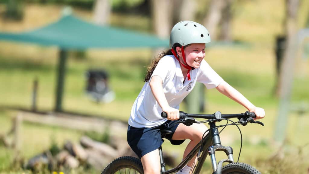 Tudor House student riding a bike in triathlon