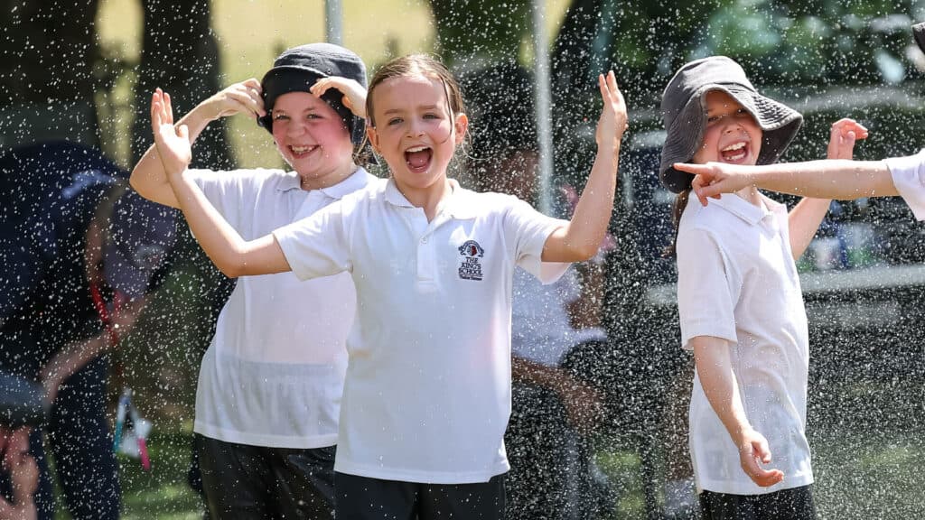 Tudor House students playing and splashing in the water with big smiles