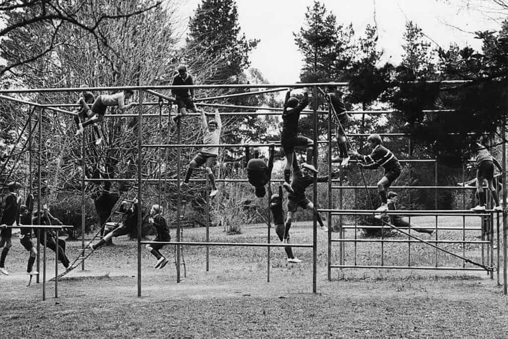 archival old black and white photo of past Tudor House students climbing and playing on a climbing structure