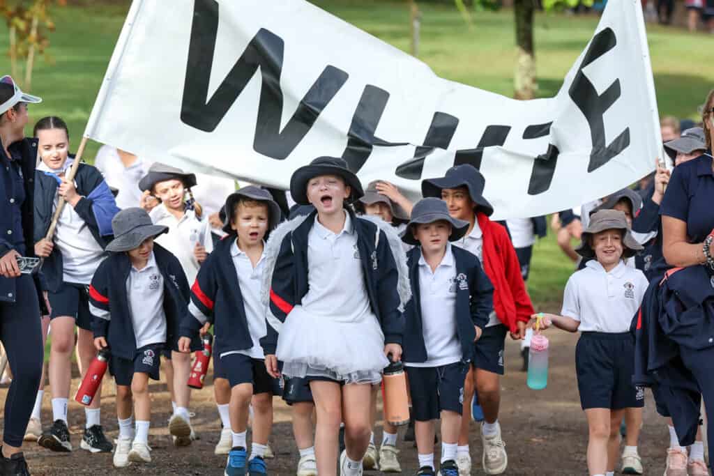 Tudor House students from the white house colour walking together and cheering