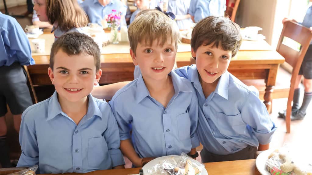 Tudor House students sitting and smiling in the dining hall
