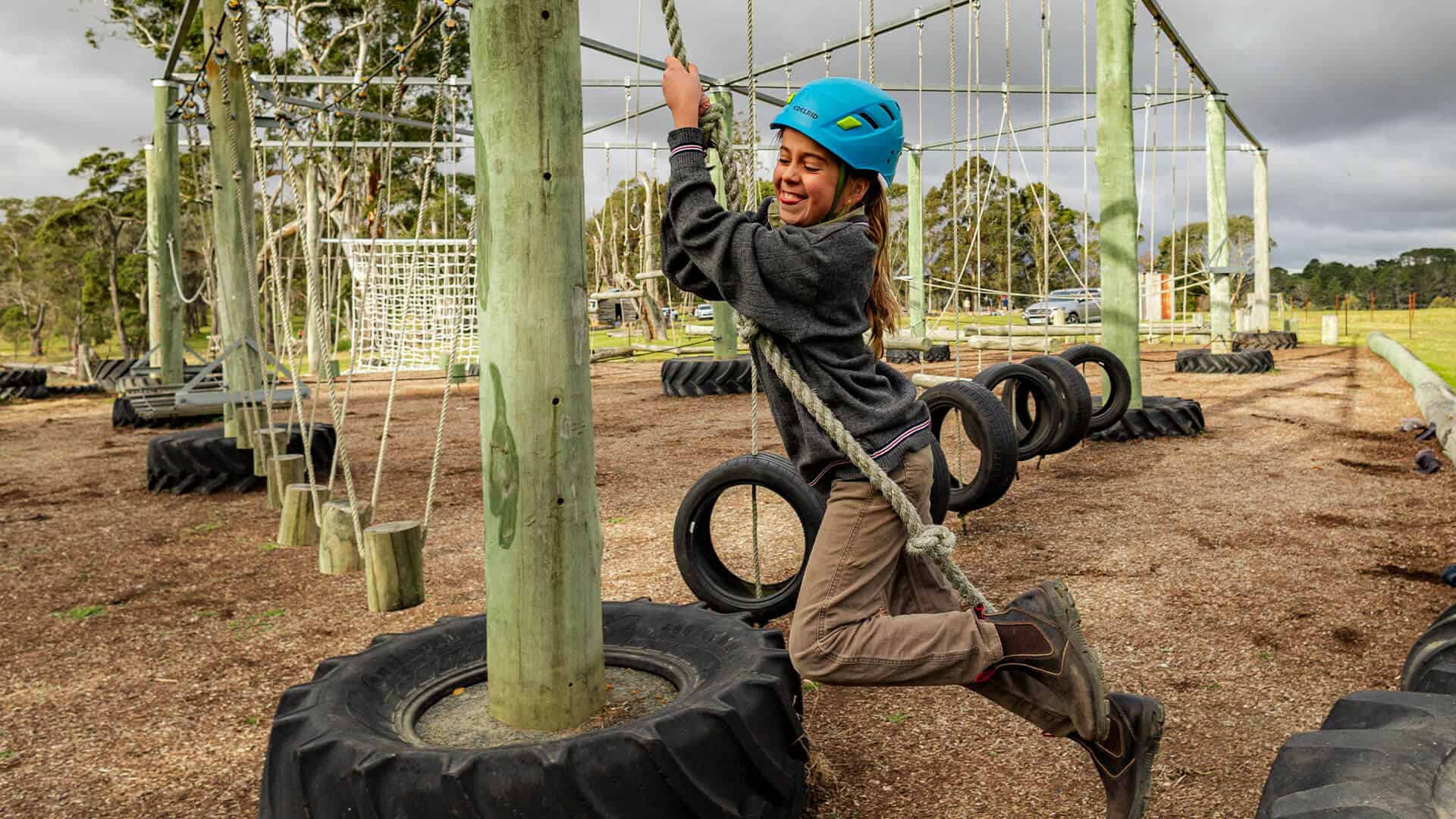 Tudor House student swinging on a rope in the high ropes course