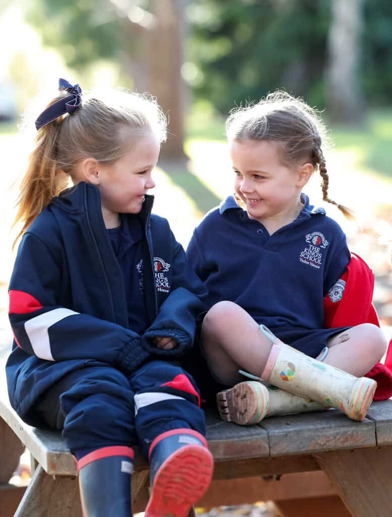 Tudor House pre-kindergarten students sitting on a picnic table in gumboots smiling